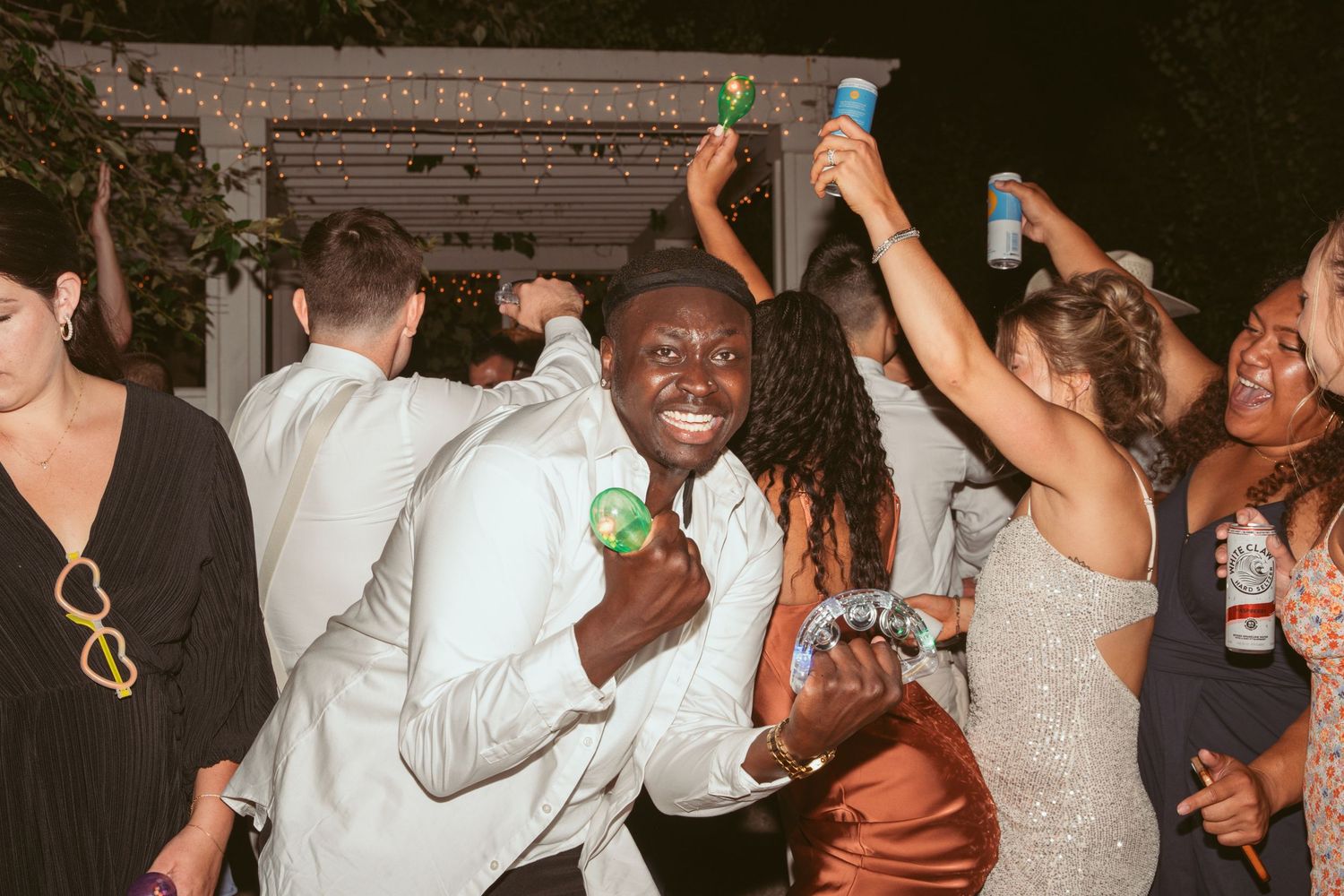 Energetic crowd dancing and having fun at a lively wedding reception.