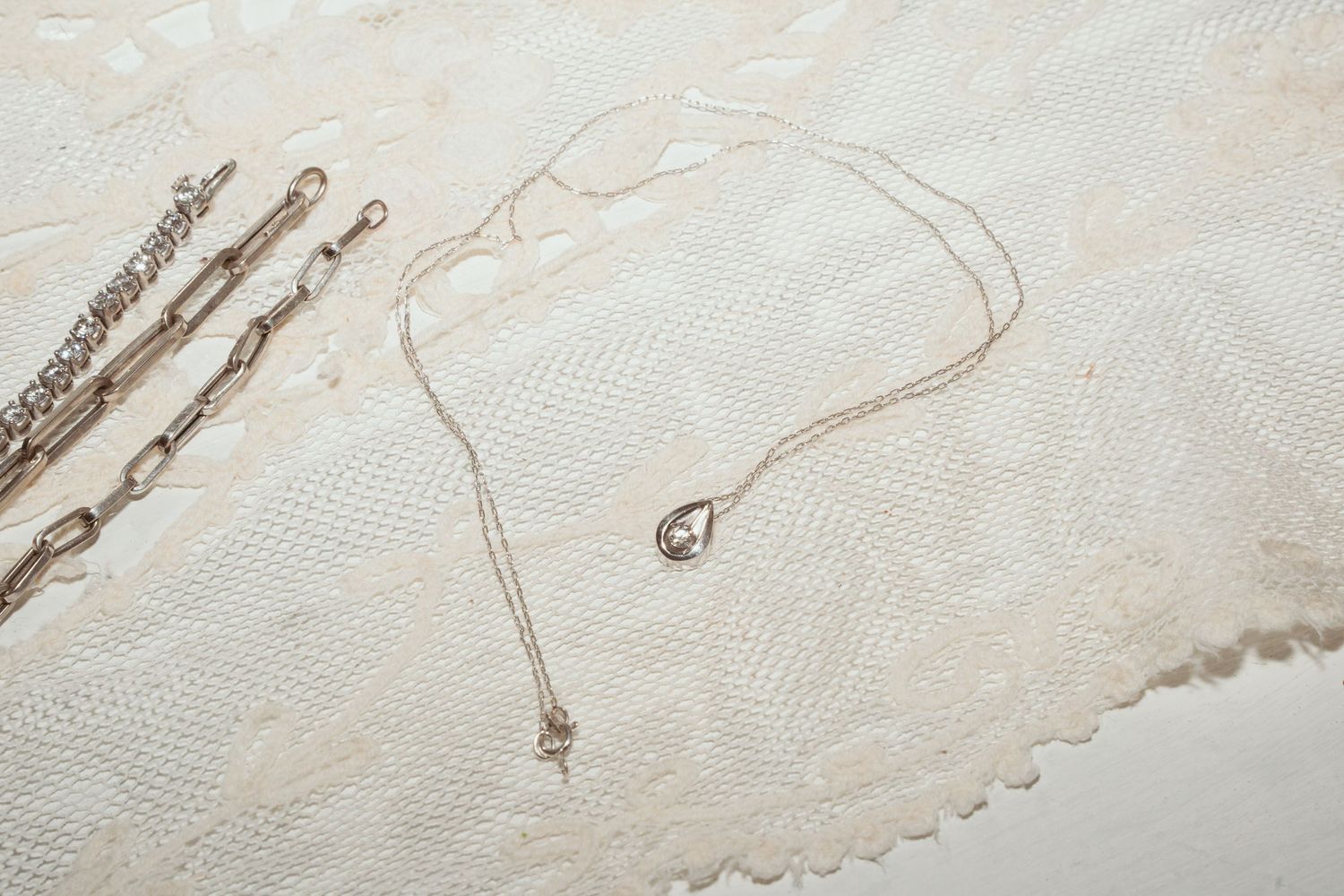 Delicate white lace fabric with intricate floral patterns and scalloped edges creates an elegant textile background.