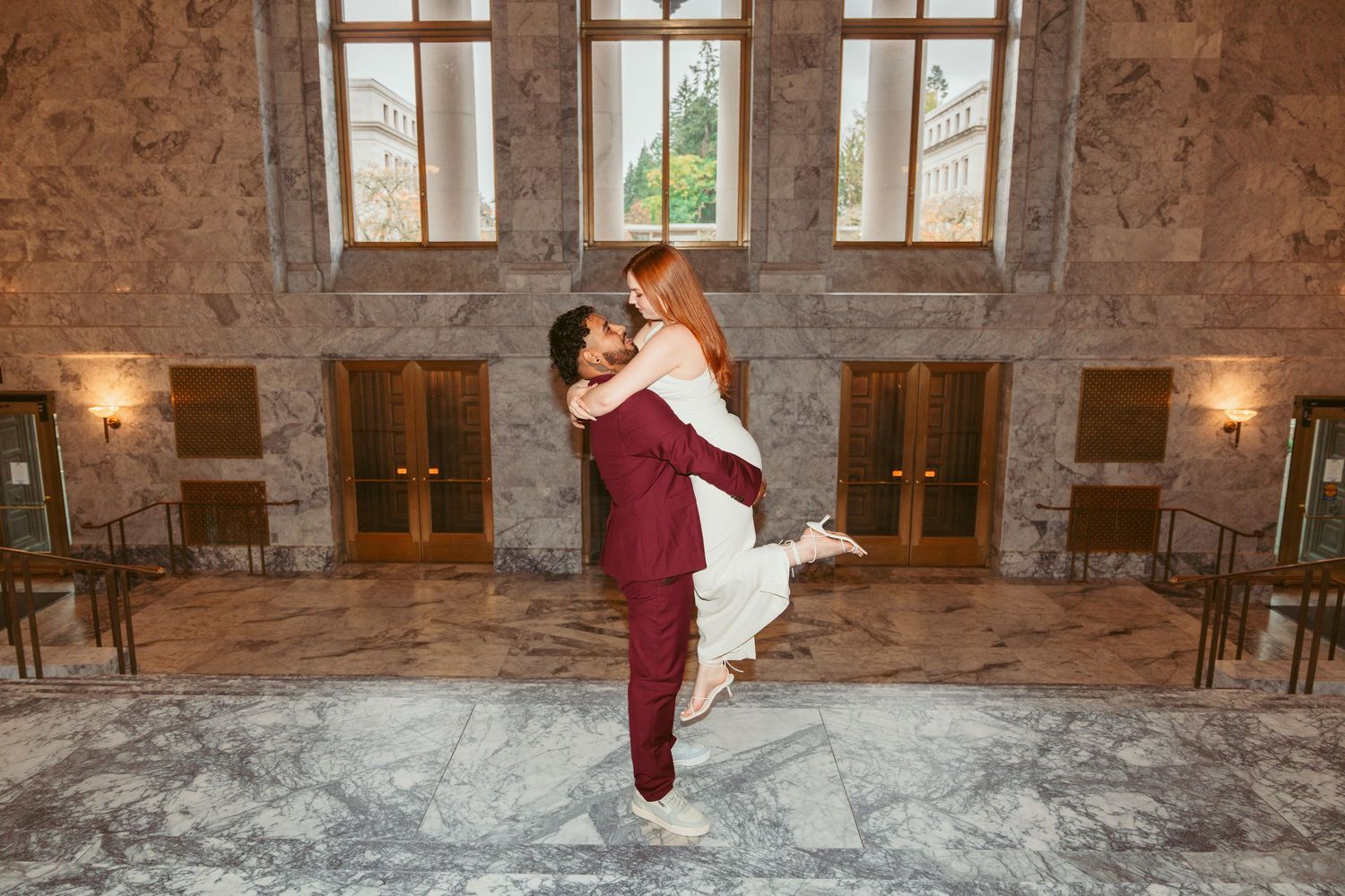 A couple shares romantic moments in a historic stone interior with warm lighting.