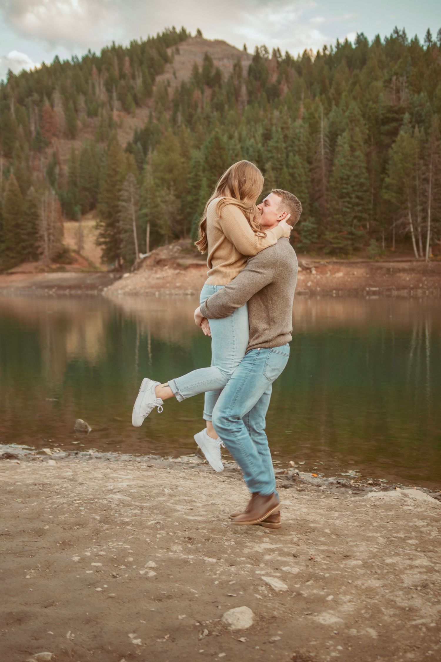 Playful moments captured at a mountain lake shore during golden hour.