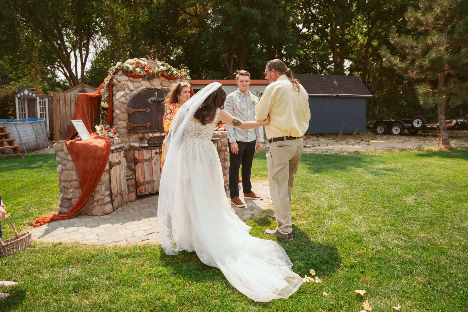 Wedding celebration scene on a green lawn with guests and decorative elements.