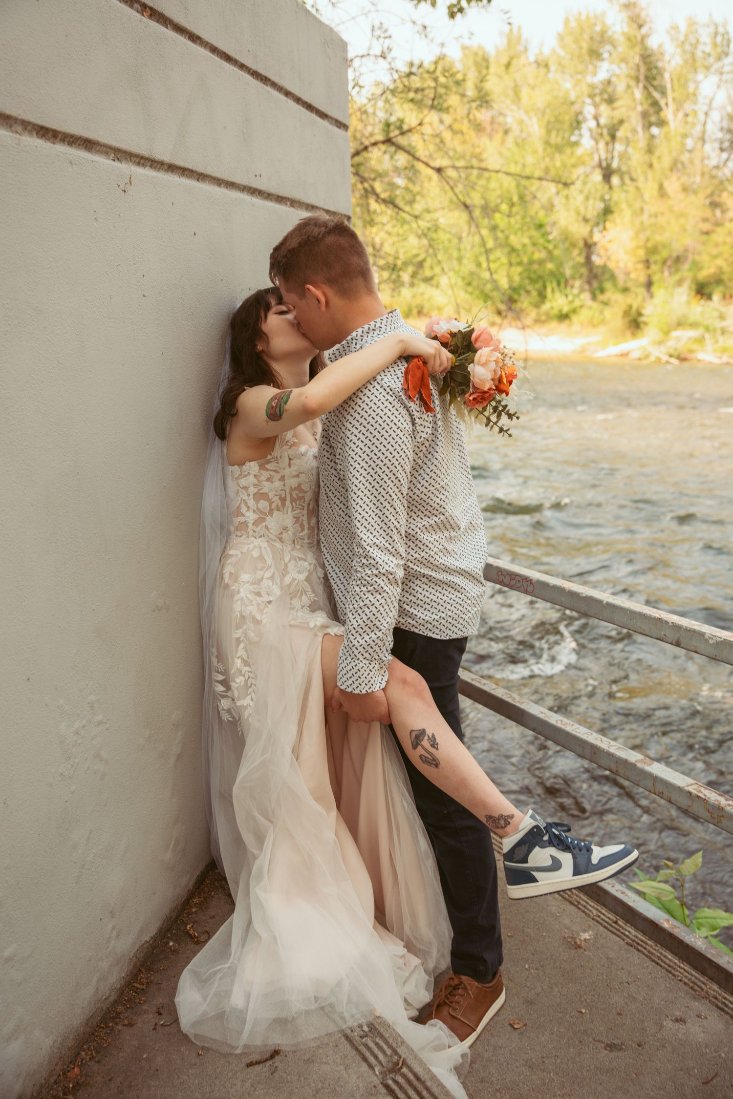Romantic wedding couple embracing in a rustic outdoor setting.