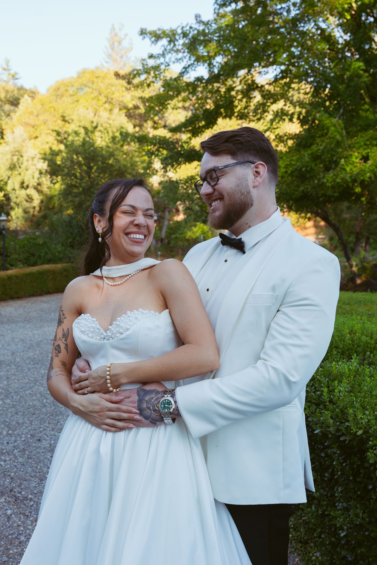 Wedding couple sharing intimate moments outdoors in a garden setting with natural lighting.