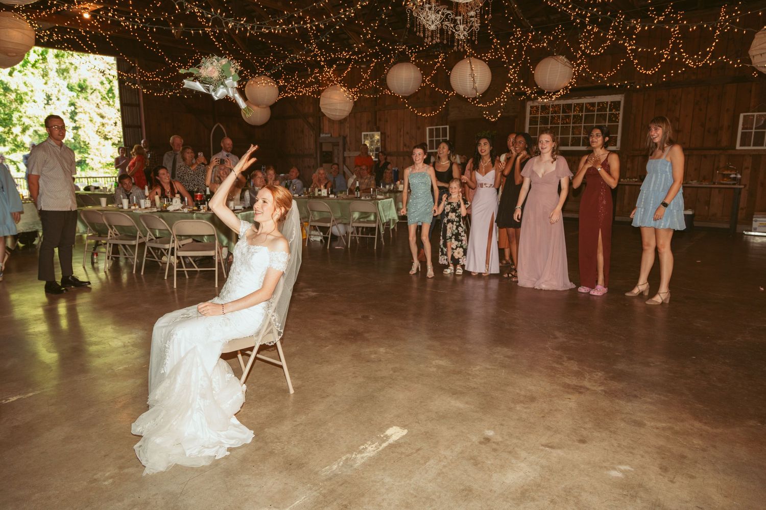 Rustic barn wedding reception venue decorated with twinkle lights and lanterns.
