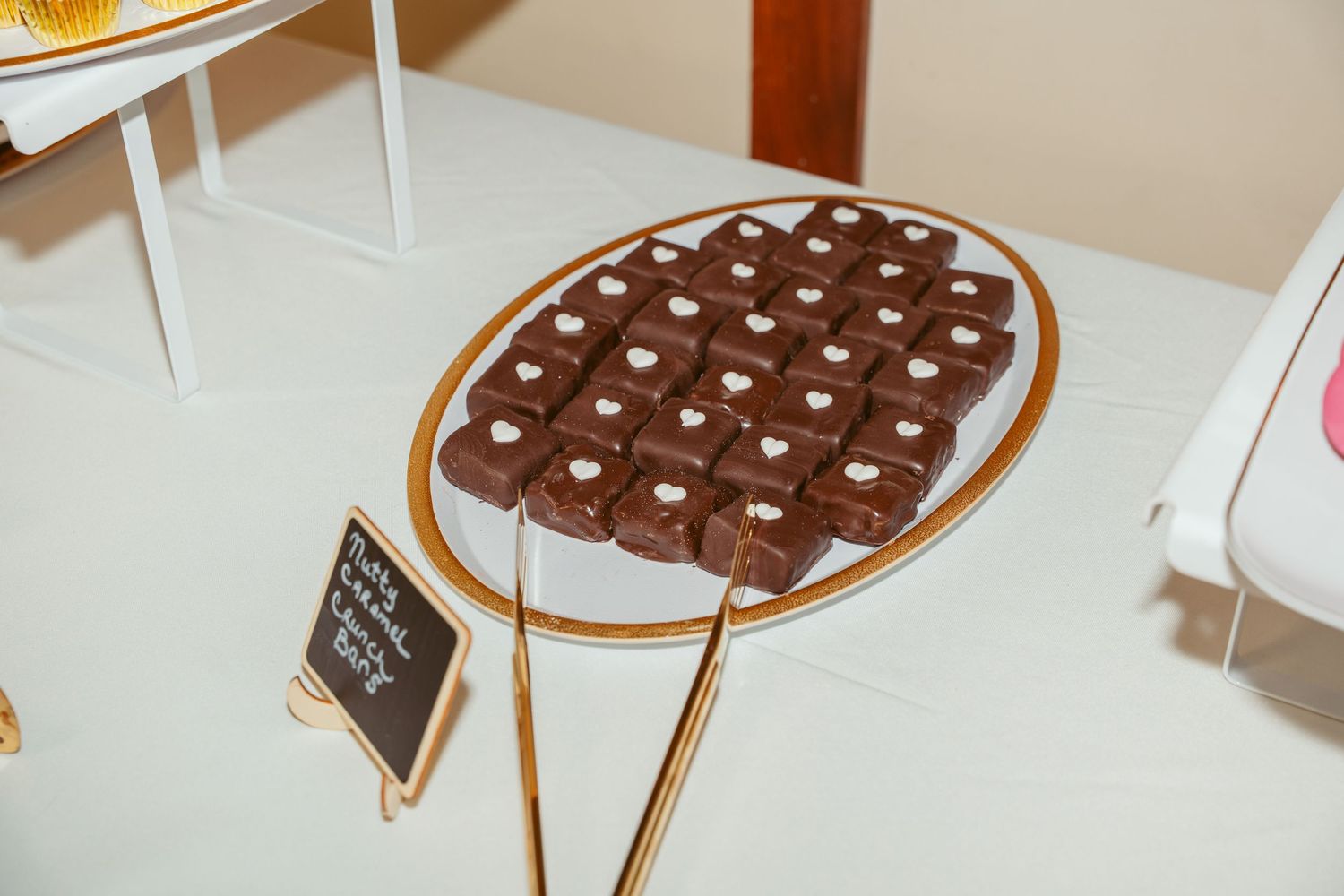 Elegant display of heart-shaped chocolate treats on a gold stand.