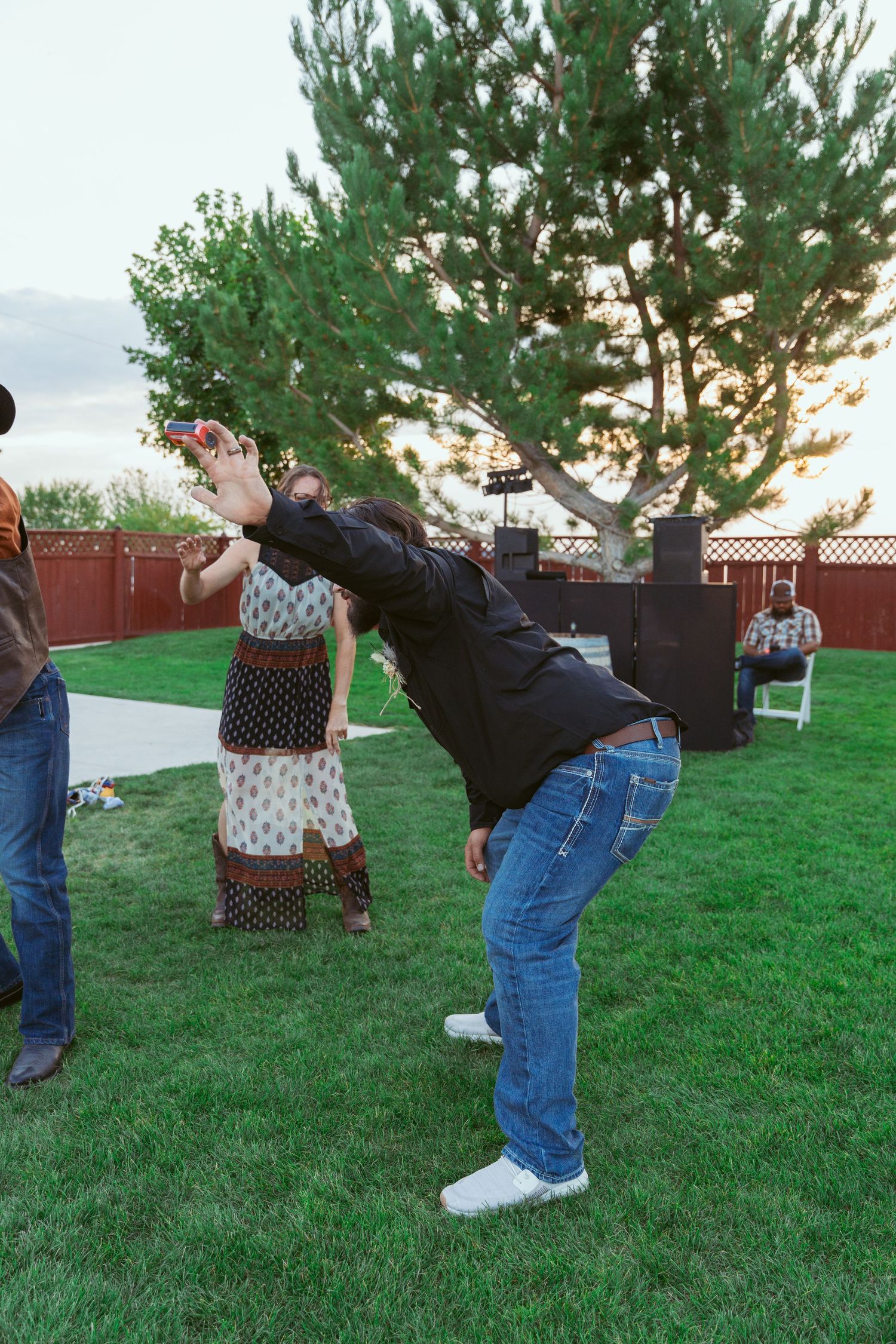 A sequence of photos showing people playing a limbo game on a grassy lawn.