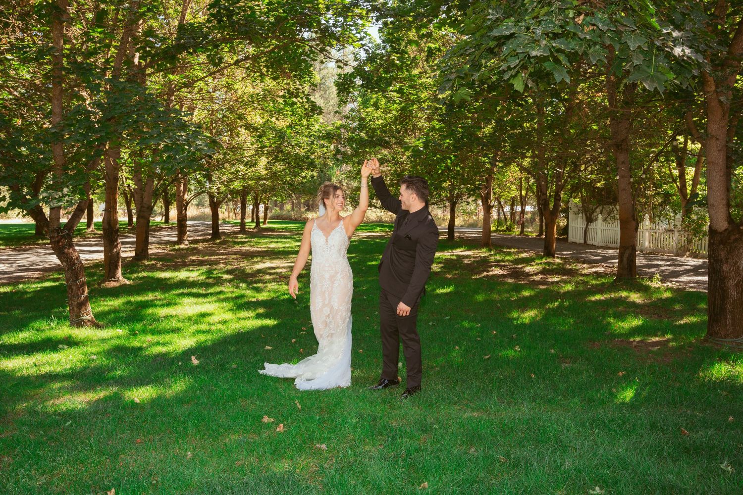 Wedding party members walk through a scenic wooded area during an outdoor photo session.