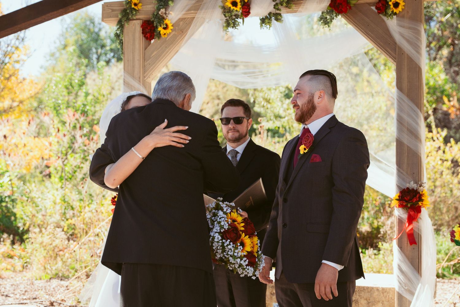 Wedding ceremony moments captured under a rustic pavilion decorated with sunflowers.