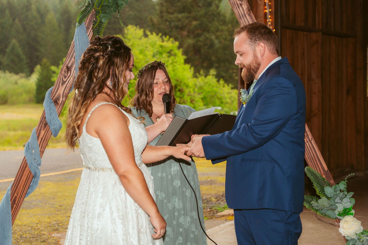Intimate wedding ceremony moments inside a rustic barn with natural lighting.
