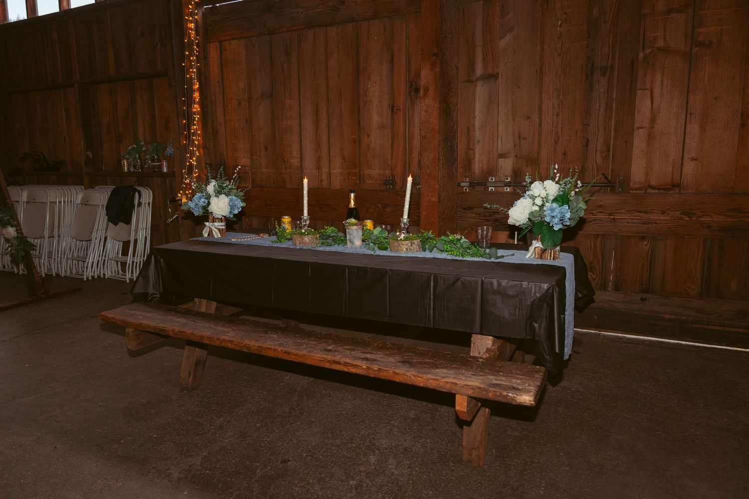 Long wooden benches arranged in rows inside a rustic barn setting.