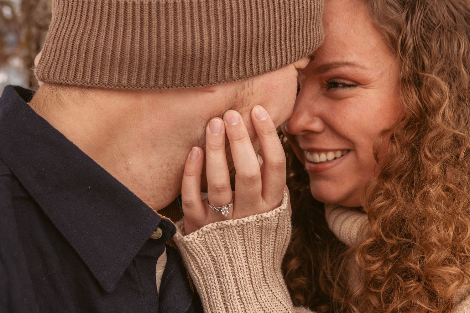 Sweet candid moment between couple during winter engagement photoshoot.