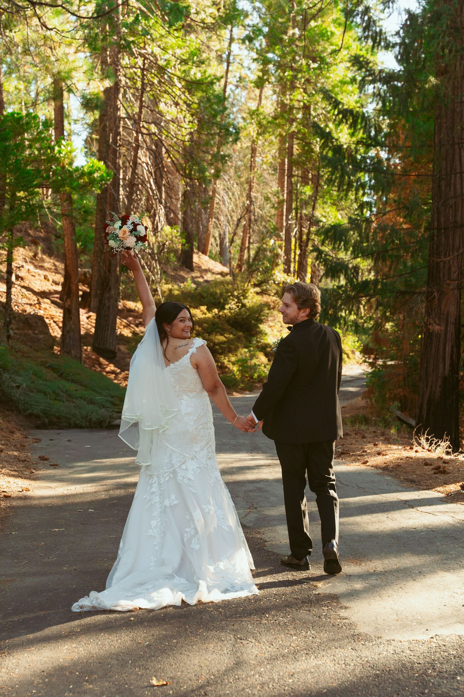 Candid wedding moments photographed on a scenic forest trail during afternoon light.