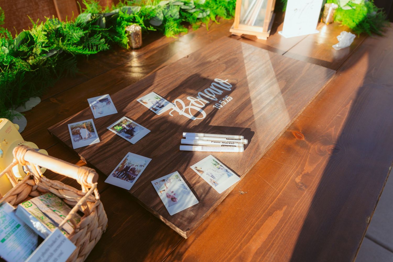 Rustic wooden table setup with place cards and greenery for wedding reception.