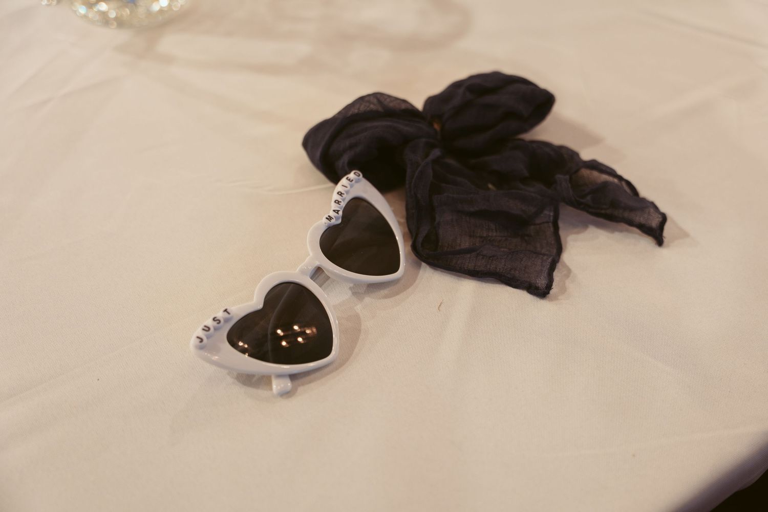 Wedding reception table settings with black napkins and place settings on white linens.