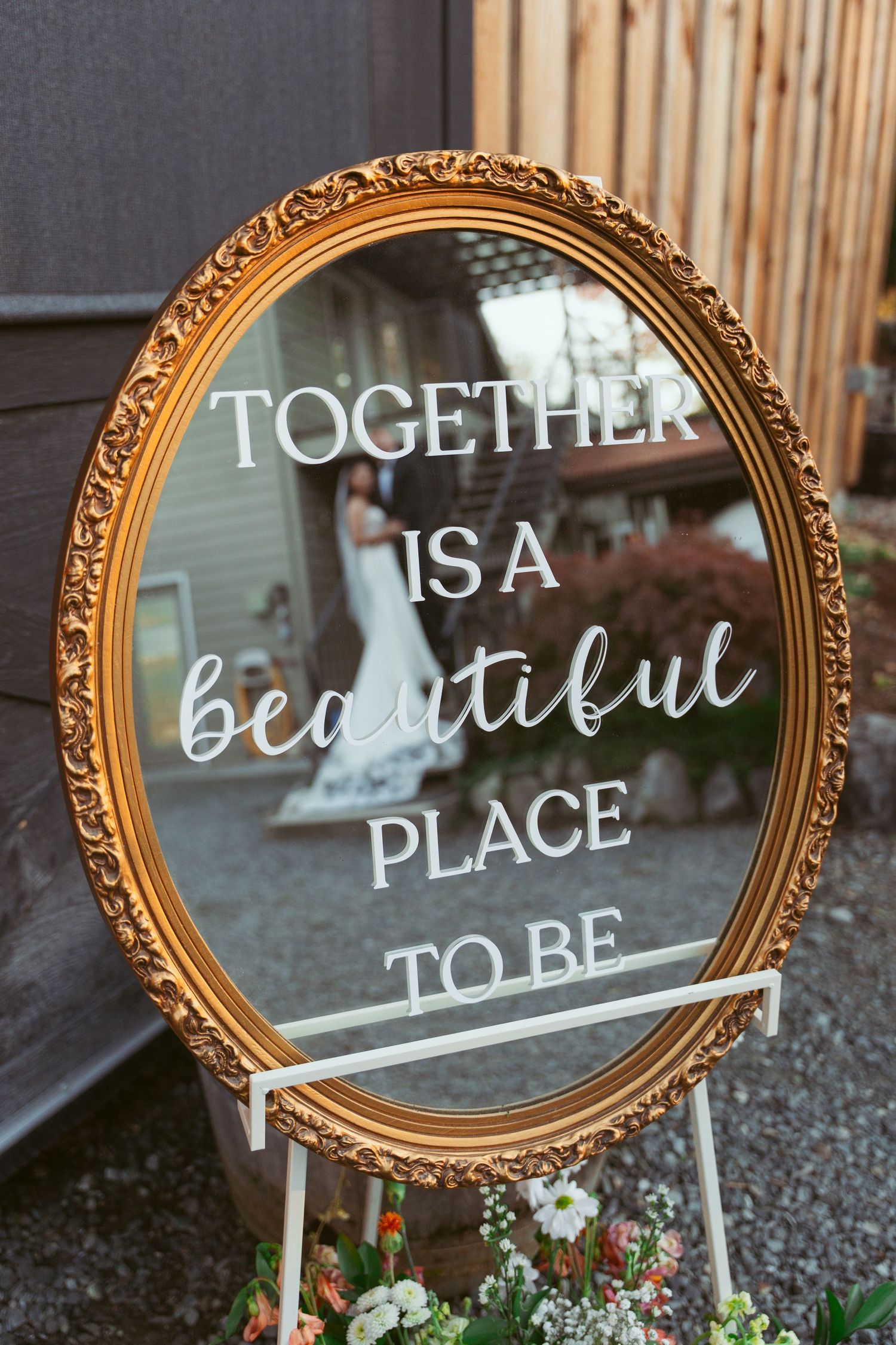 Ornate gold mirror with wedding quote 'Together is a beautiful place to be' displayed on easel.