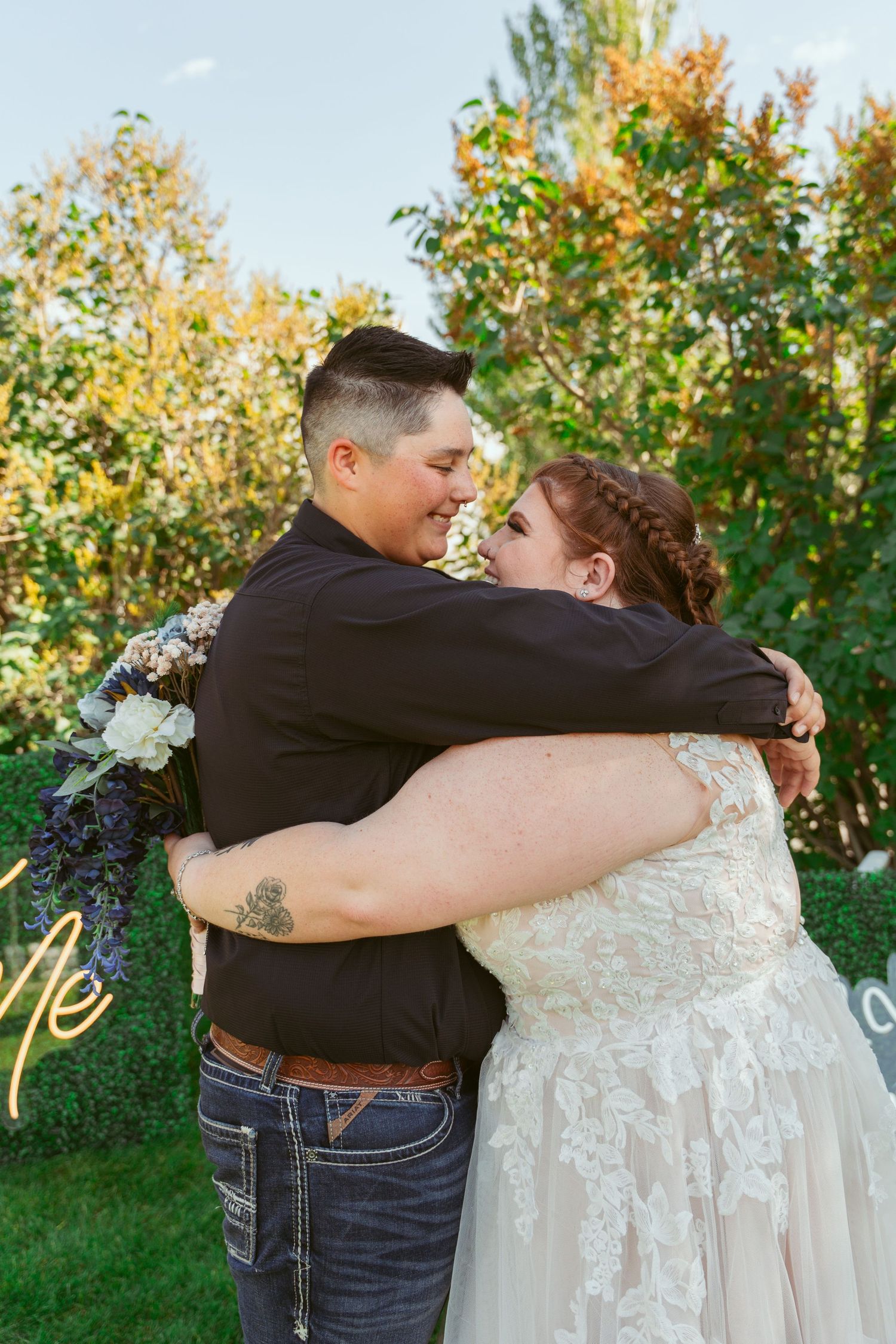 A romantic outdoor wedding photoshoot with a couple embracing against a backdrop of autumn foliage.