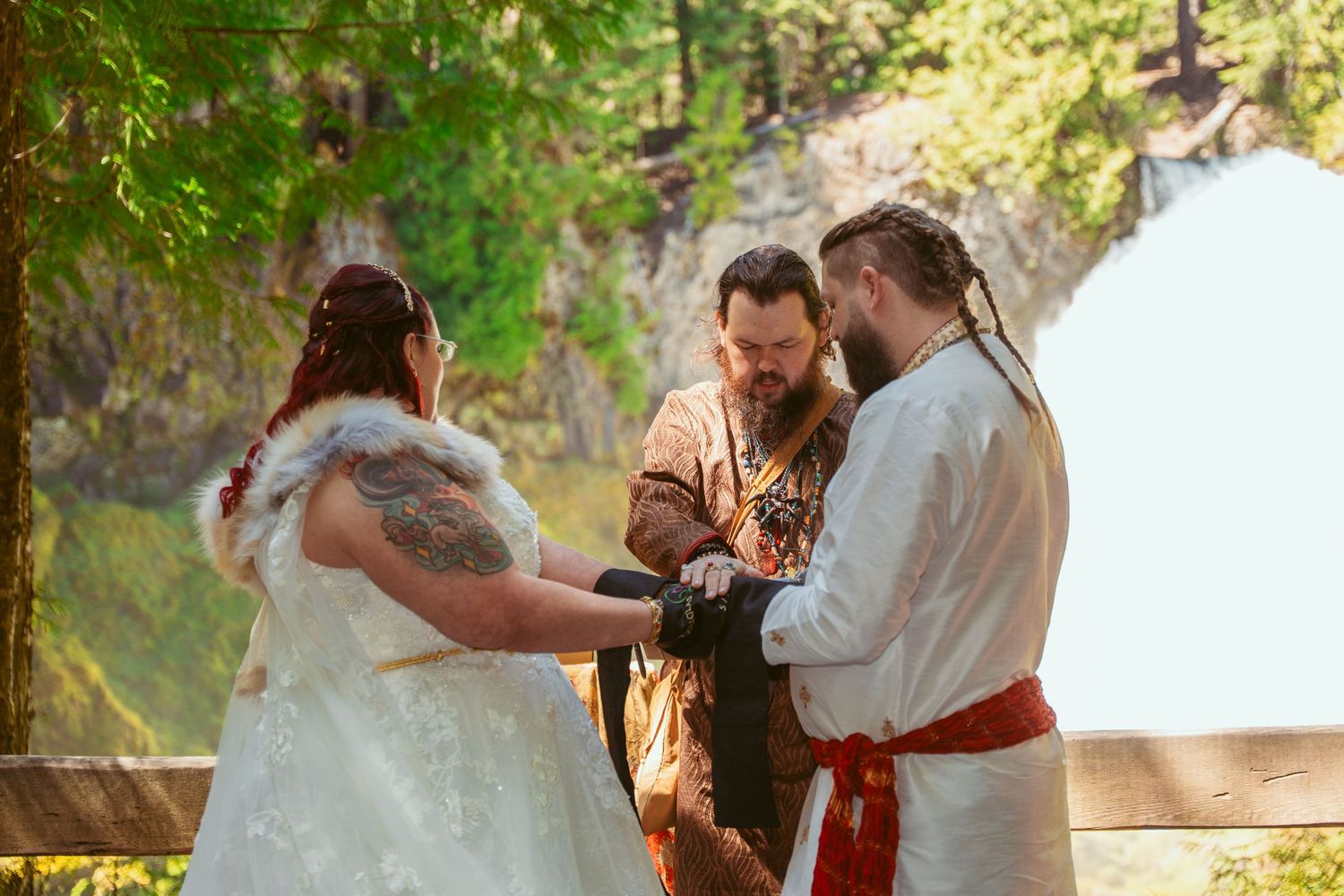 A couple dances together in a forest setting during their wedding celebration.
