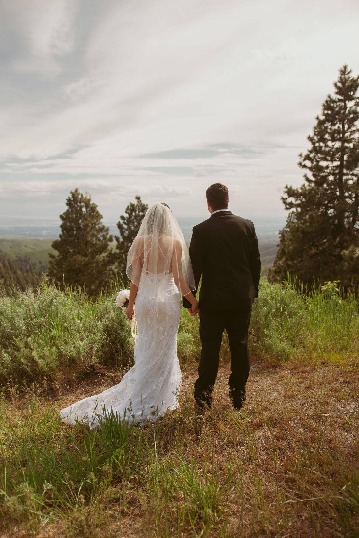 Couple walking together on a scenic mountain path during their wedding.