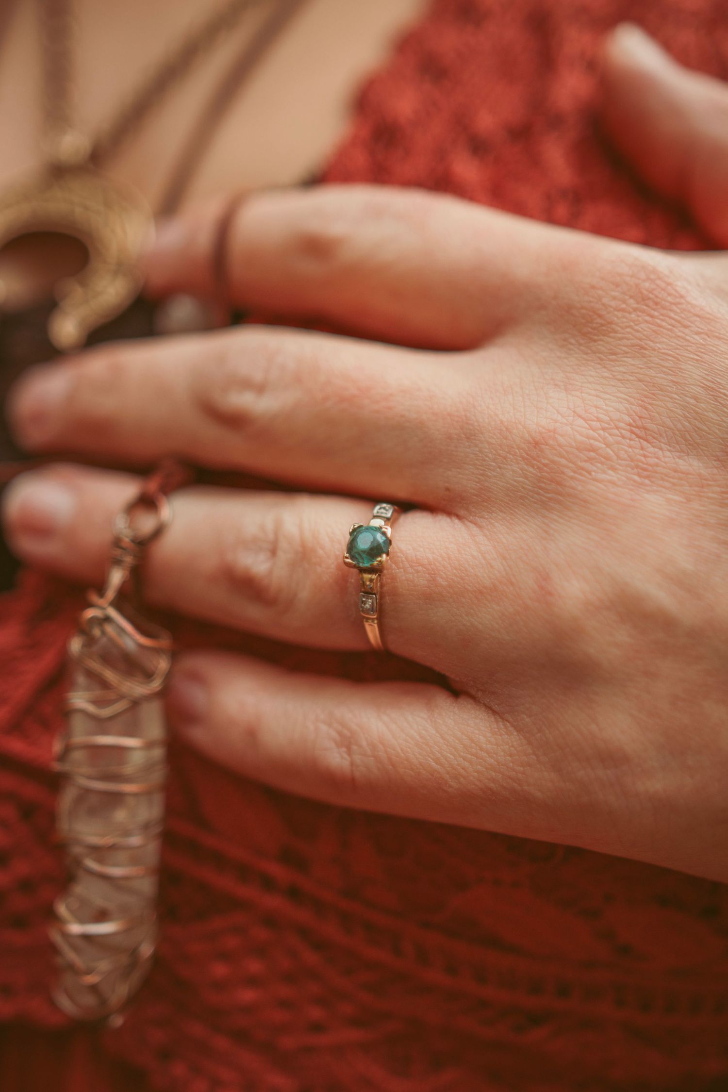 A close-up series of hands wearing rings against a red textured background.