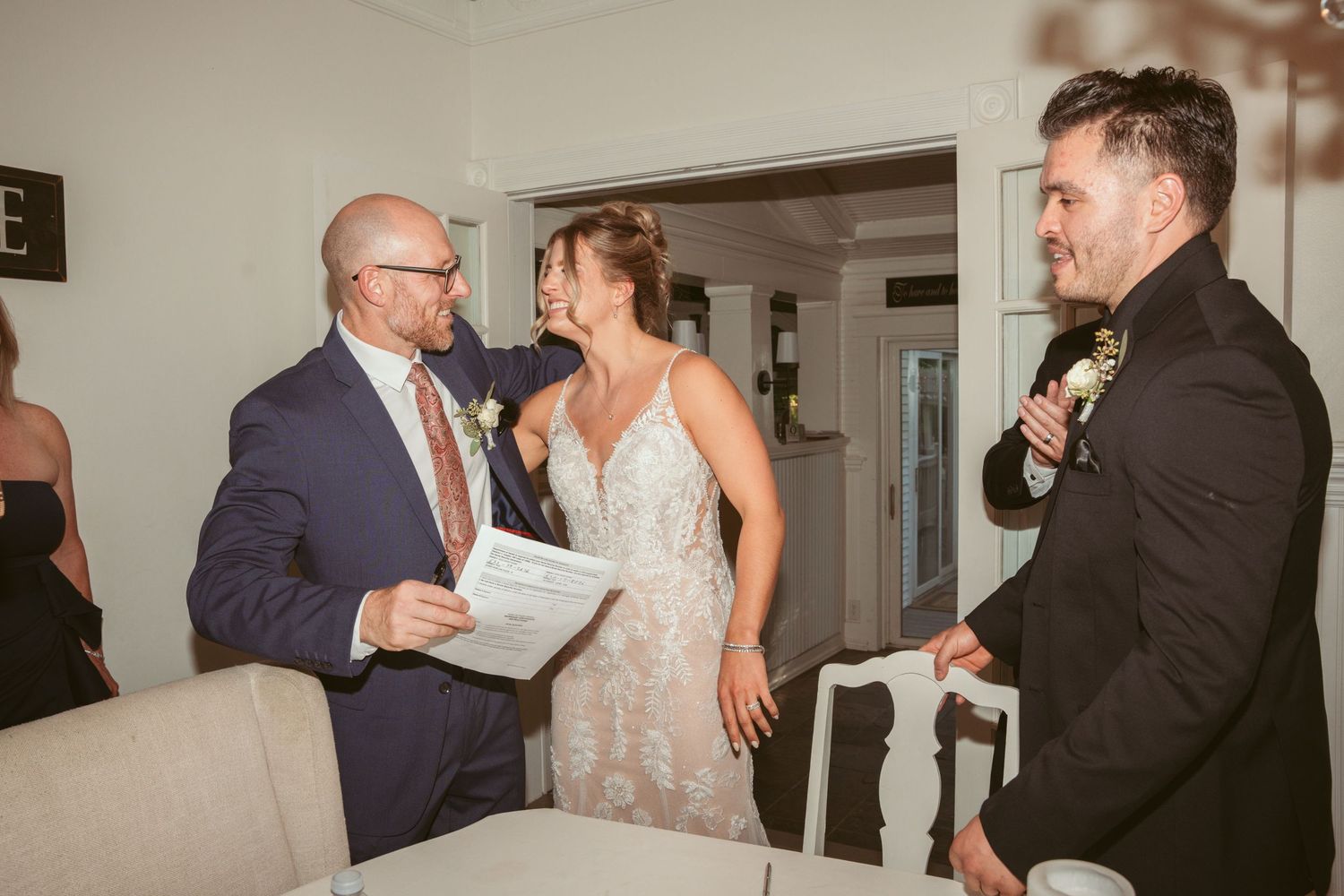 Indoor wedding reception celebration with guests dancing and mingling in an elegant venue.