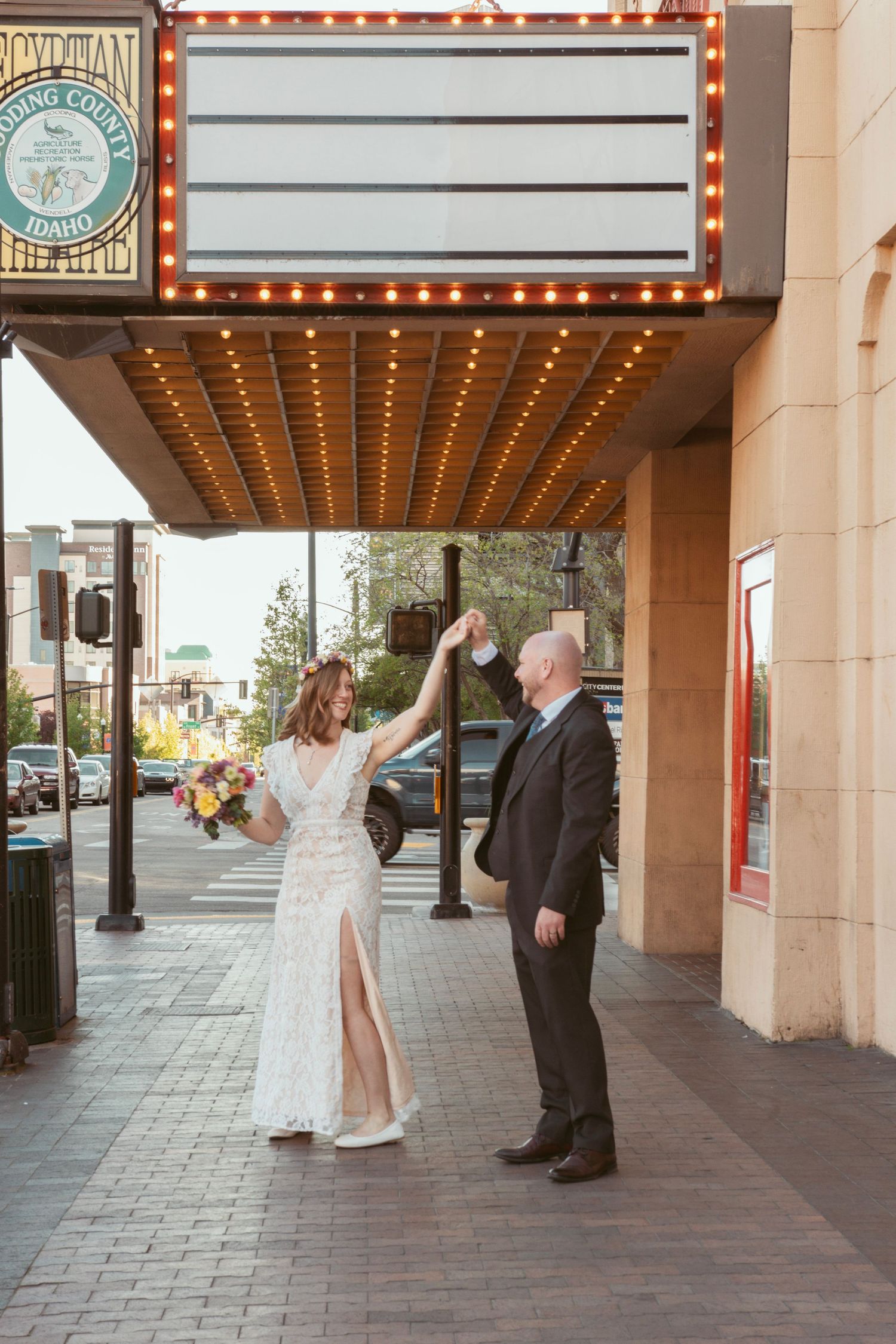 Dancing under a vintage theater marquee with twinkling lights.