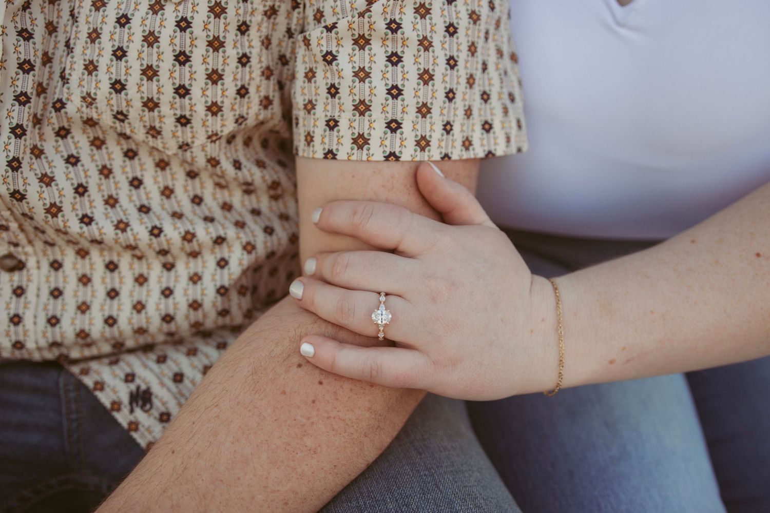 Detail shots of couple's hands and engagement ring in warm natural lighting.