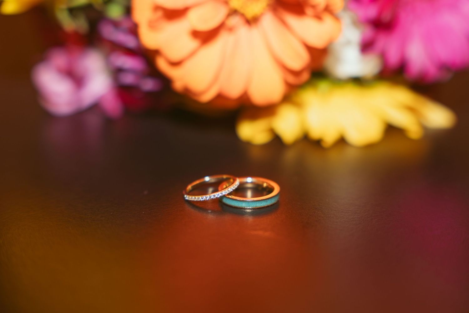 Wedding rings displayed among colorful flower petals.