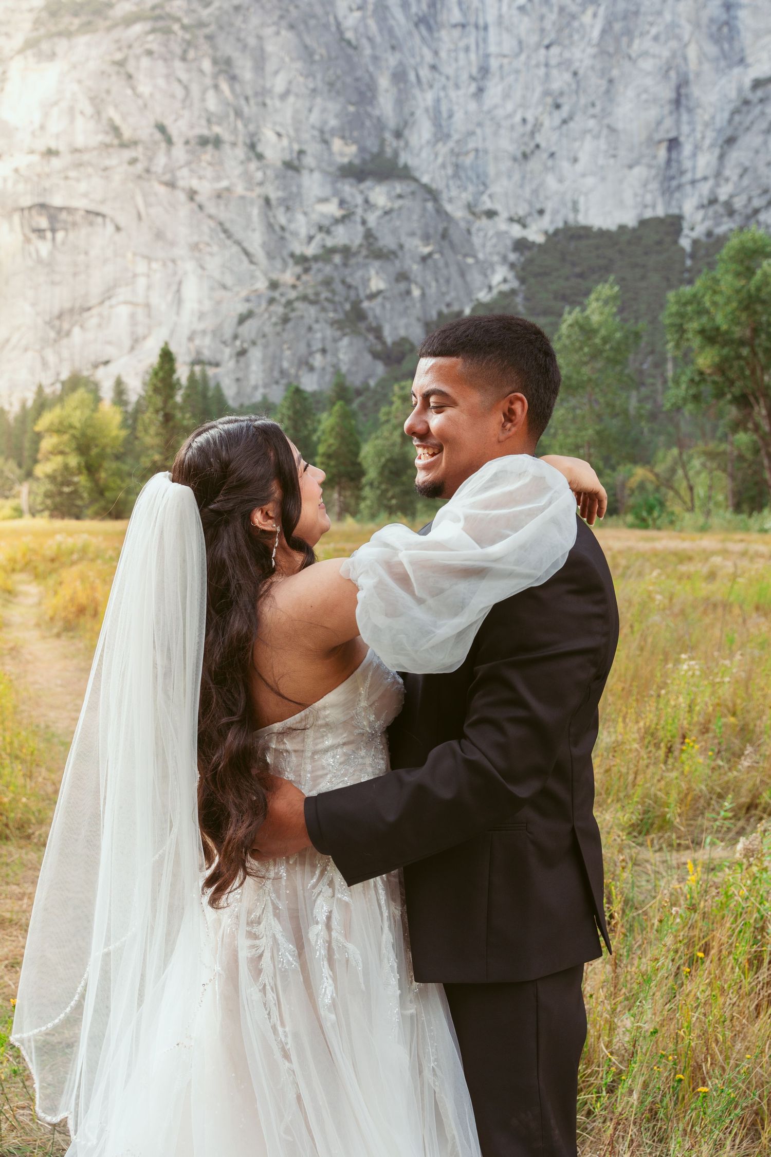 Intimate wedding moment captured in Yosemite meadow with dramatic mountain scenery.