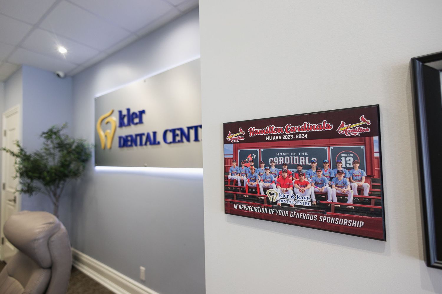 Interior of Kier Dental Centre featuring branded wall sign and a St. Louis Cardinals youth baseball team sponsorship plaque.