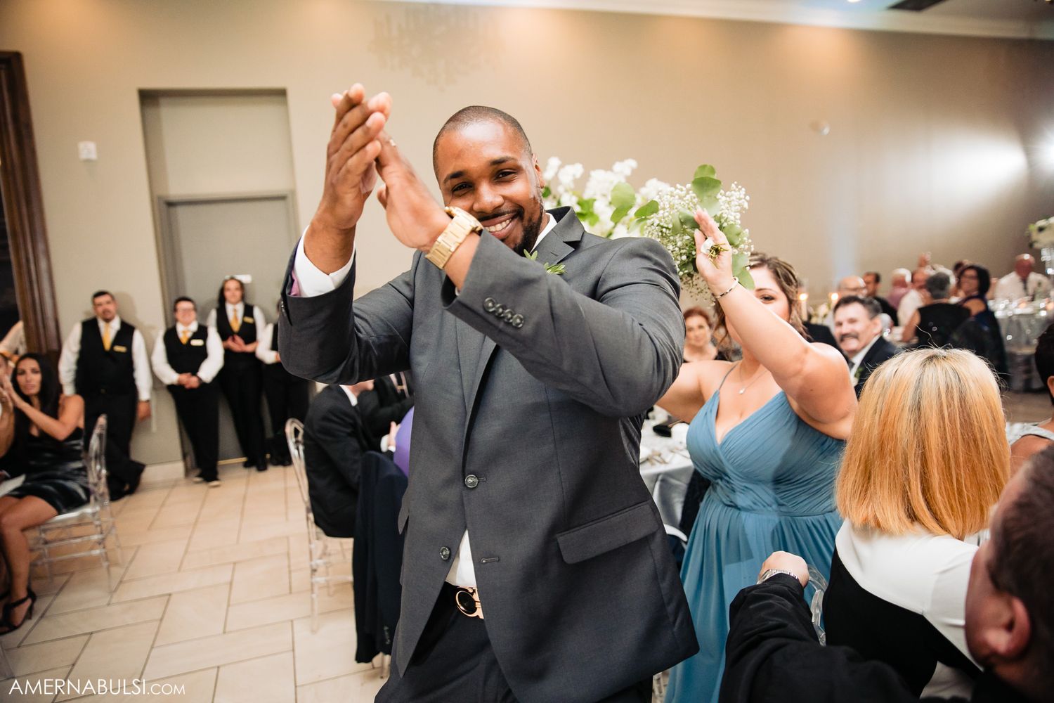 A joyful celebration moment during a wedding reception with attendees cheering.