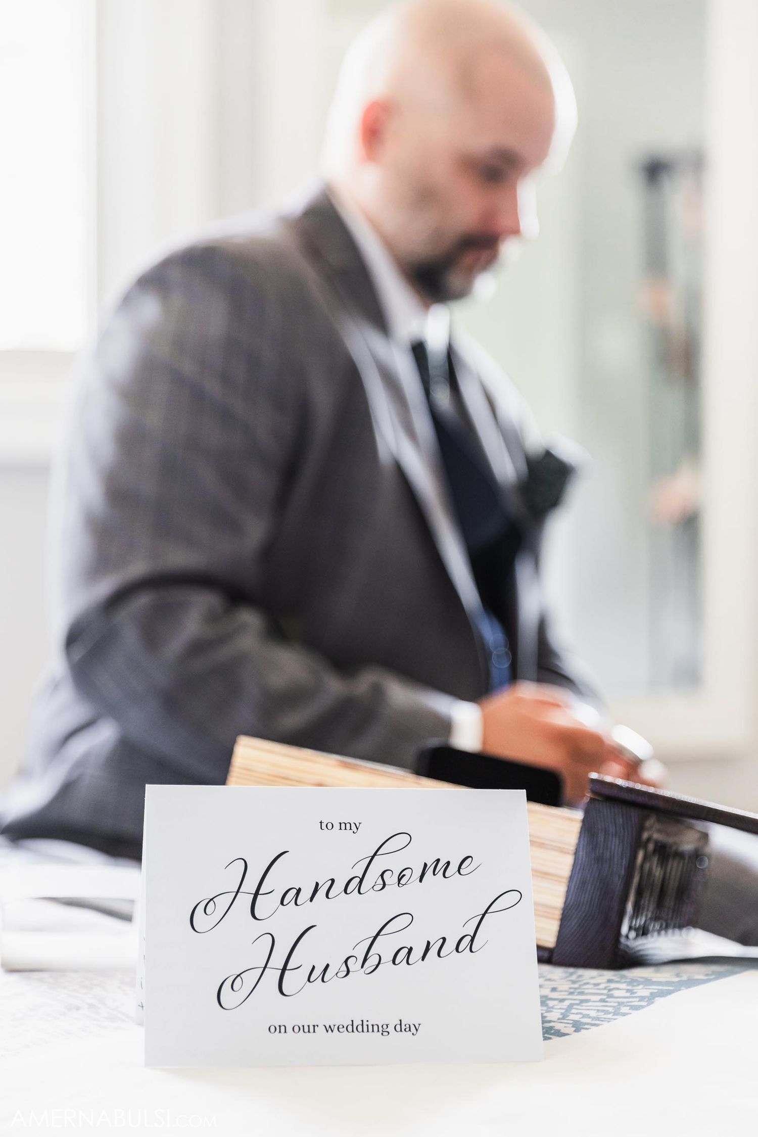 Wedding card that says 'To my Handsome Husband' with elegant calligraphy sits on a table.