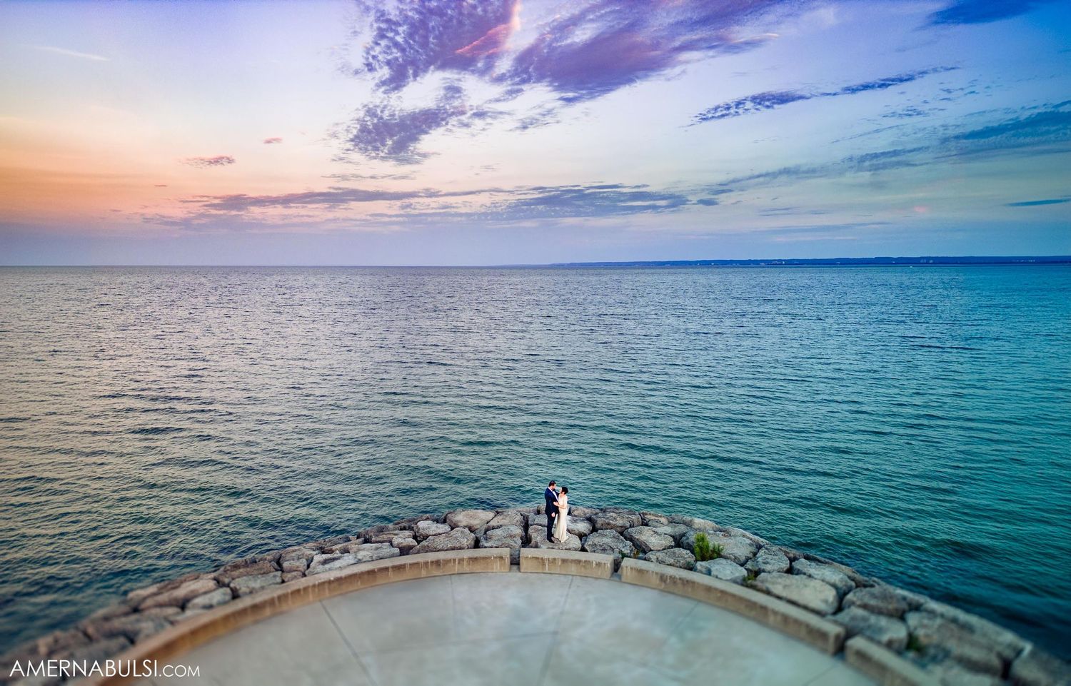 Scenic ocean view at sunset from a curved balcony observation point.