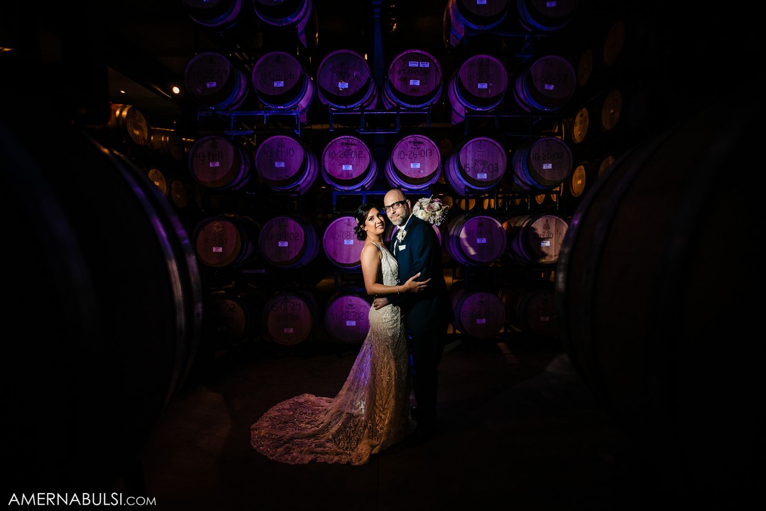 Purple stage lights create a dramatic backlit silhouette effect in a dark performance space.
