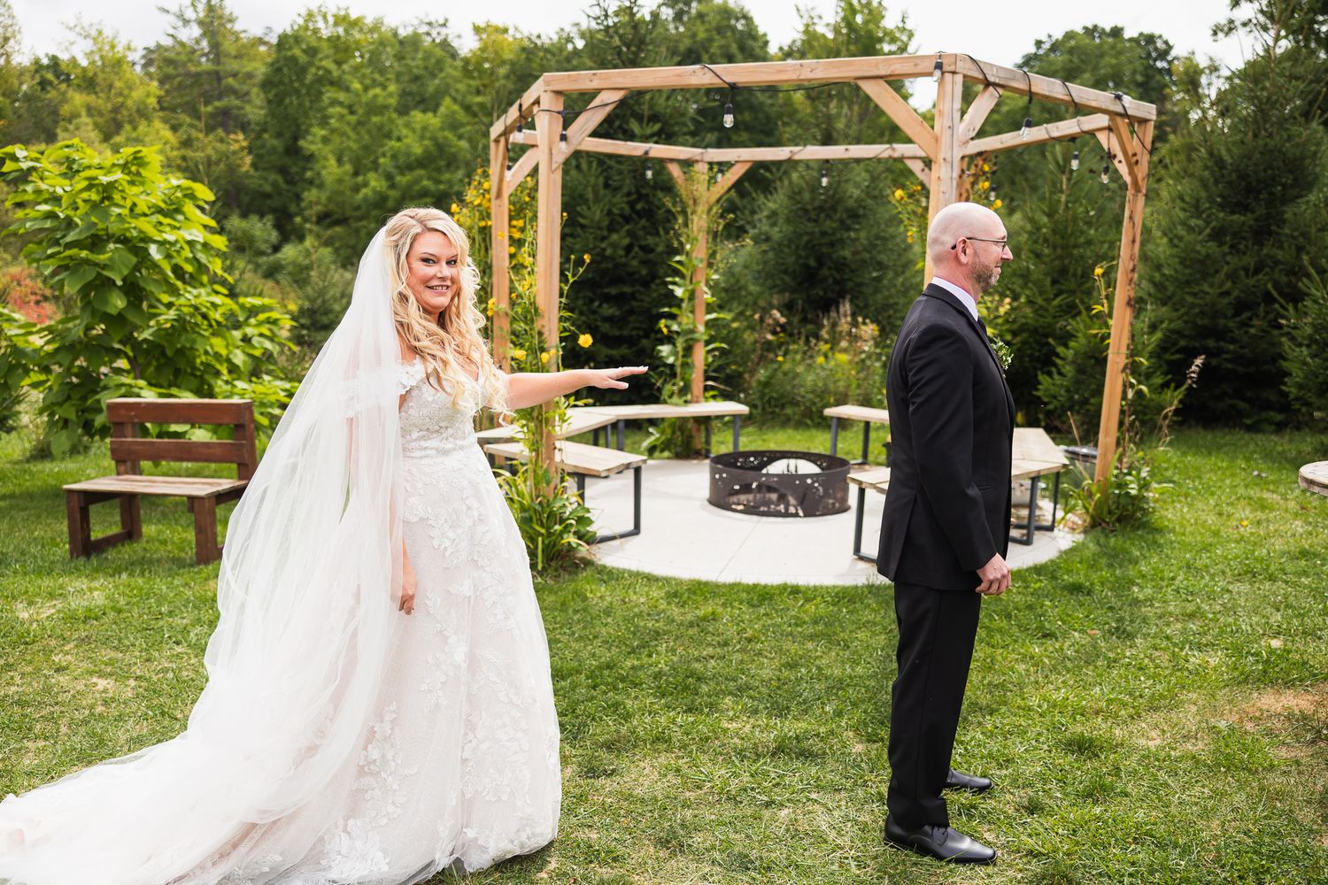 A rustic outdoor wedding scene with wooden arbors and lush greenery creating a natural ceremony backdrop.