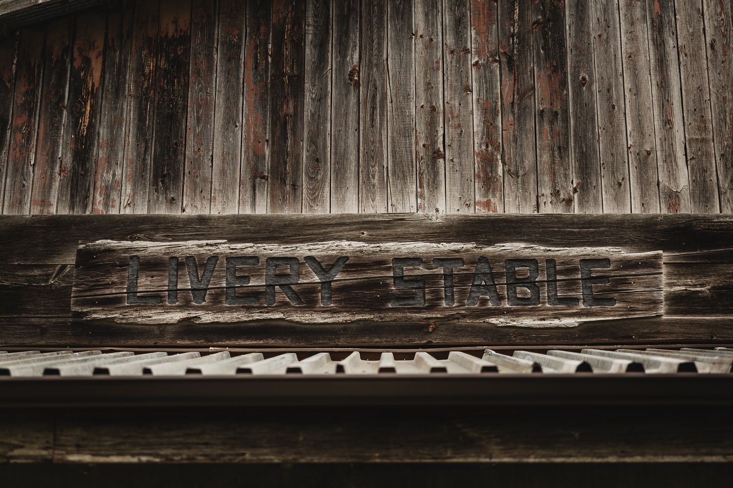 Weathered wooden barn wall texture creates dramatic backdrop for rustic wedding decor.