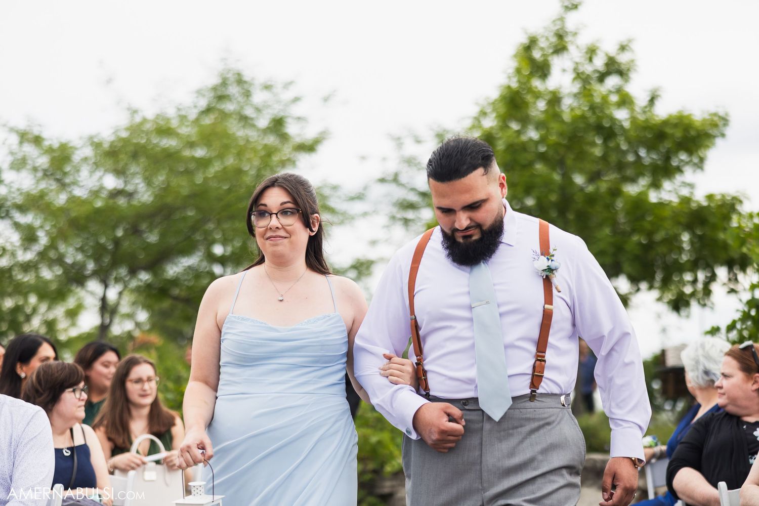 Outdoor garden wedding reception with guests mingling in casual summer attire.
