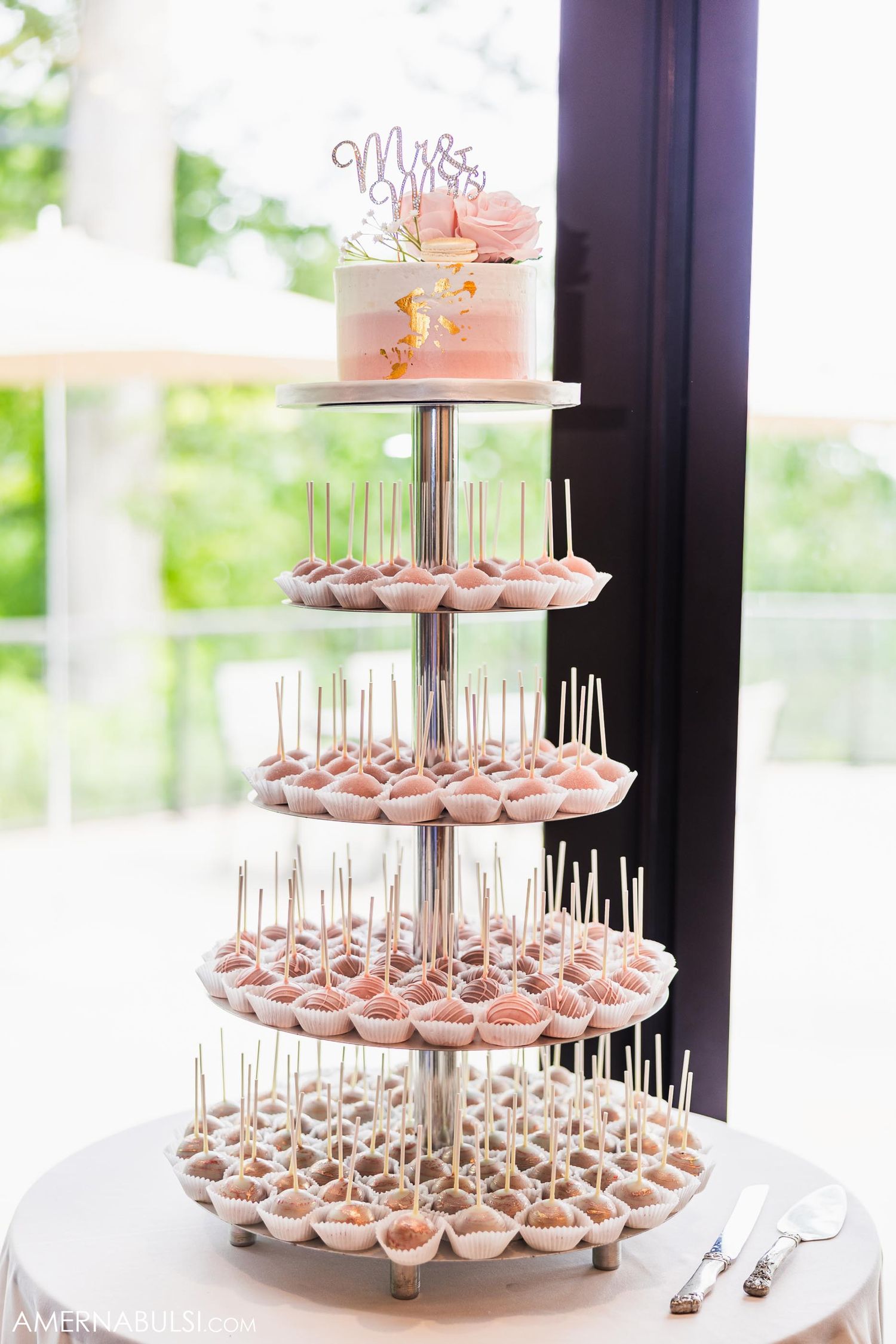 Elegant tiered display of pink desserts topped with 'Mr & Mrs' cake topper.