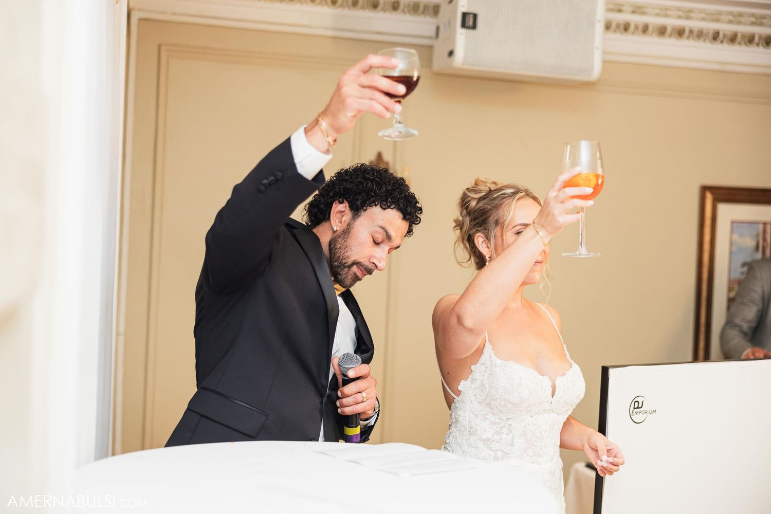 Couple toasting with wine glasses at wedding reception.