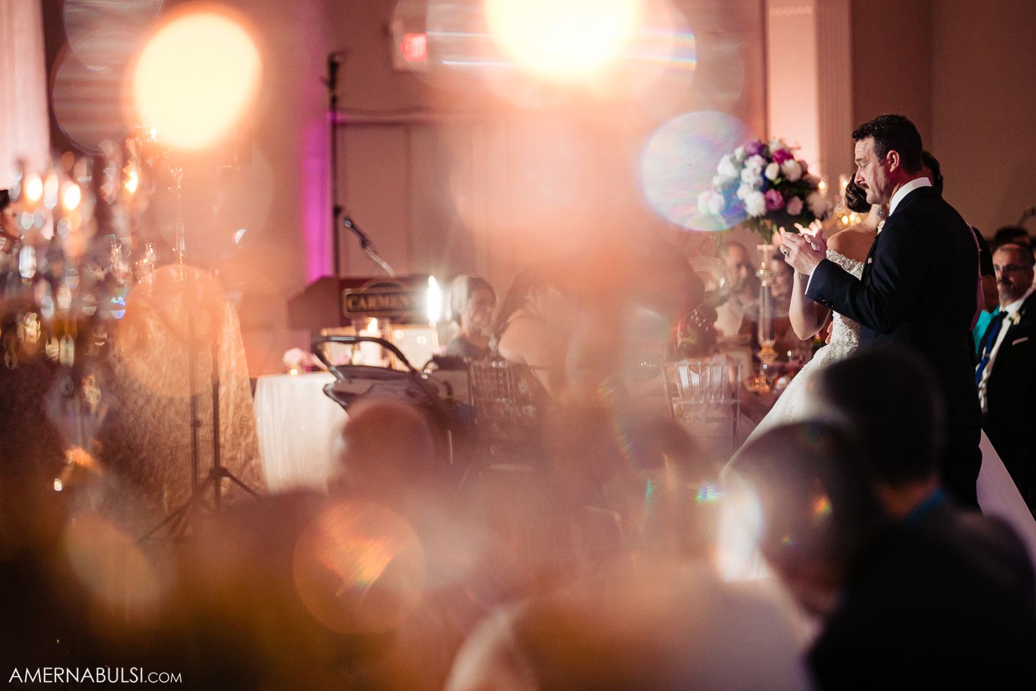 Soft focus wedding reception scene with warm ambient lighting creating a romantic atmosphere.