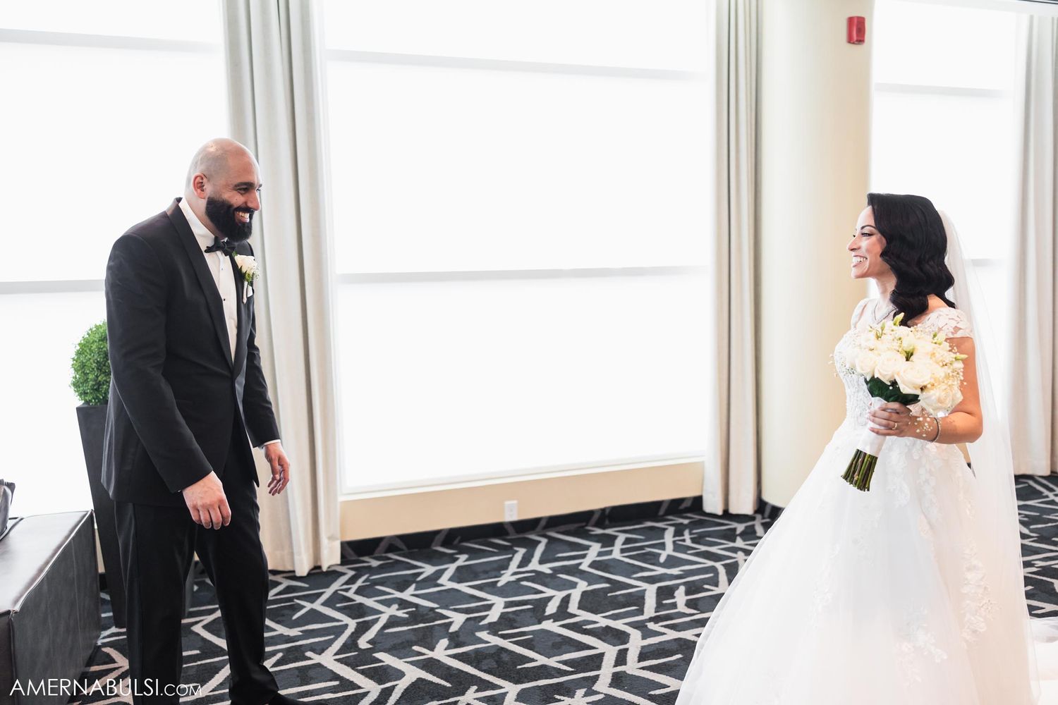 Candid wedding moment captured in bright modern interior space.