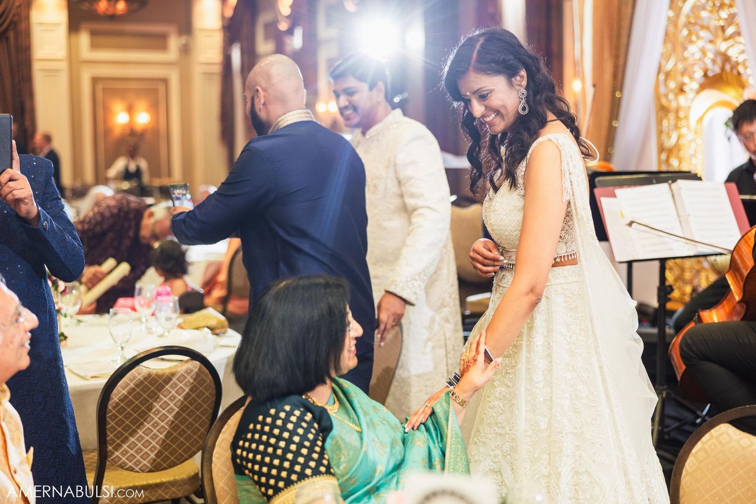 Wedding couple mingles with guests near musicians at their reception venue.