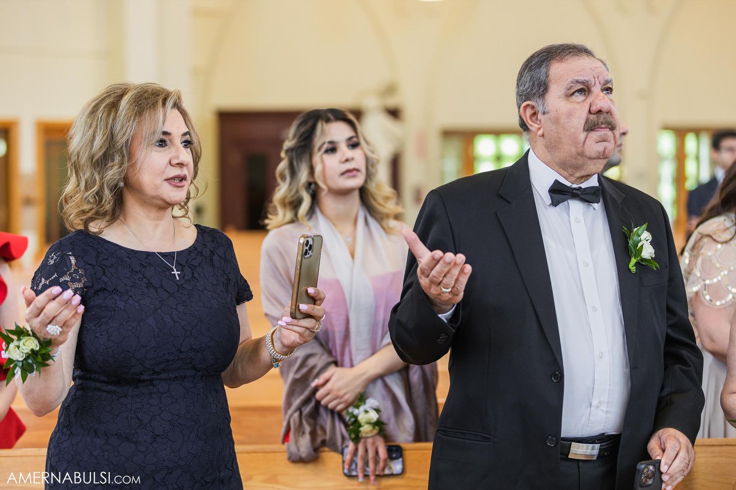 Formally dressed wedding guests observe the ceremony in a church.