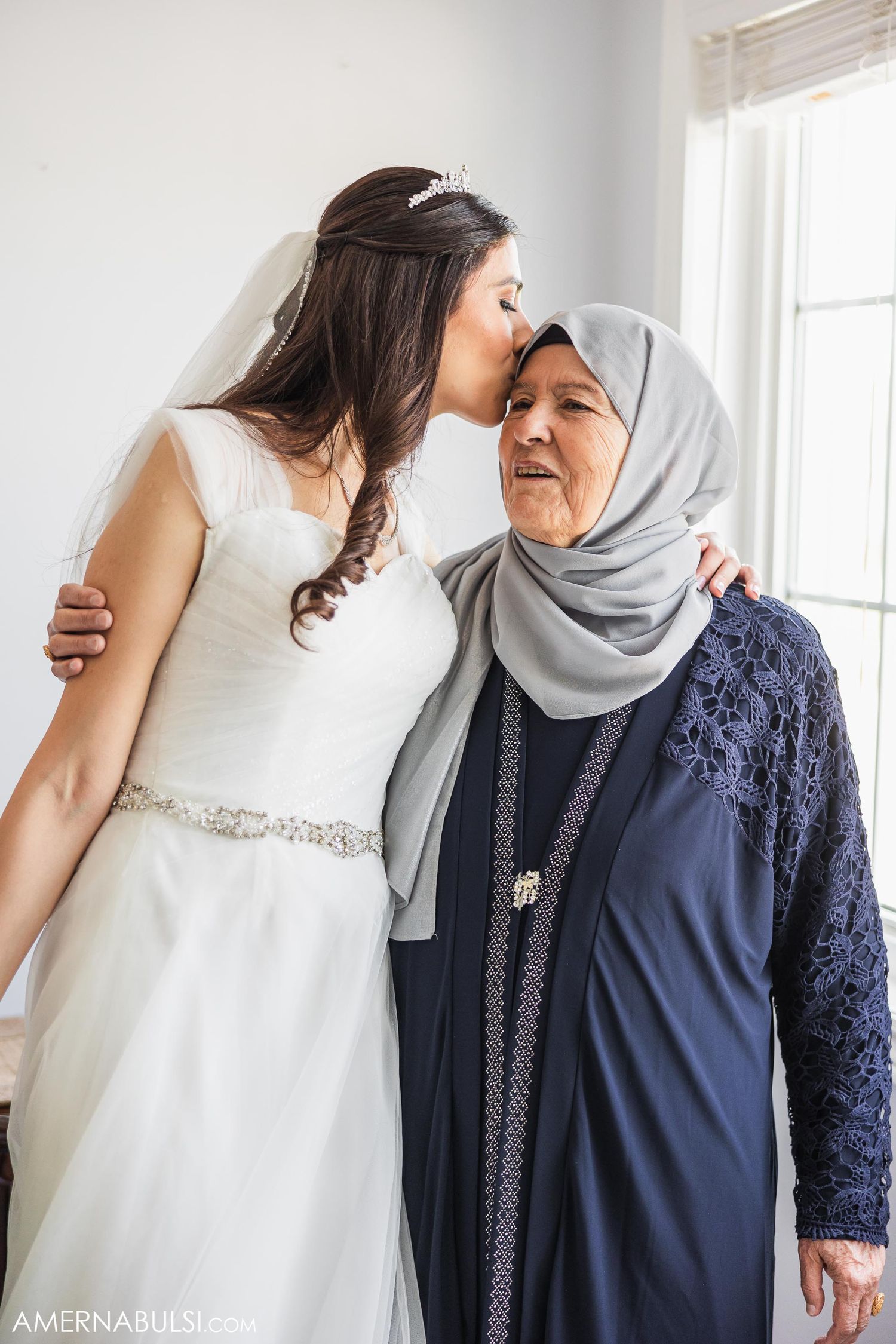 A touching moment between two women in formal wear sharing an embrace.