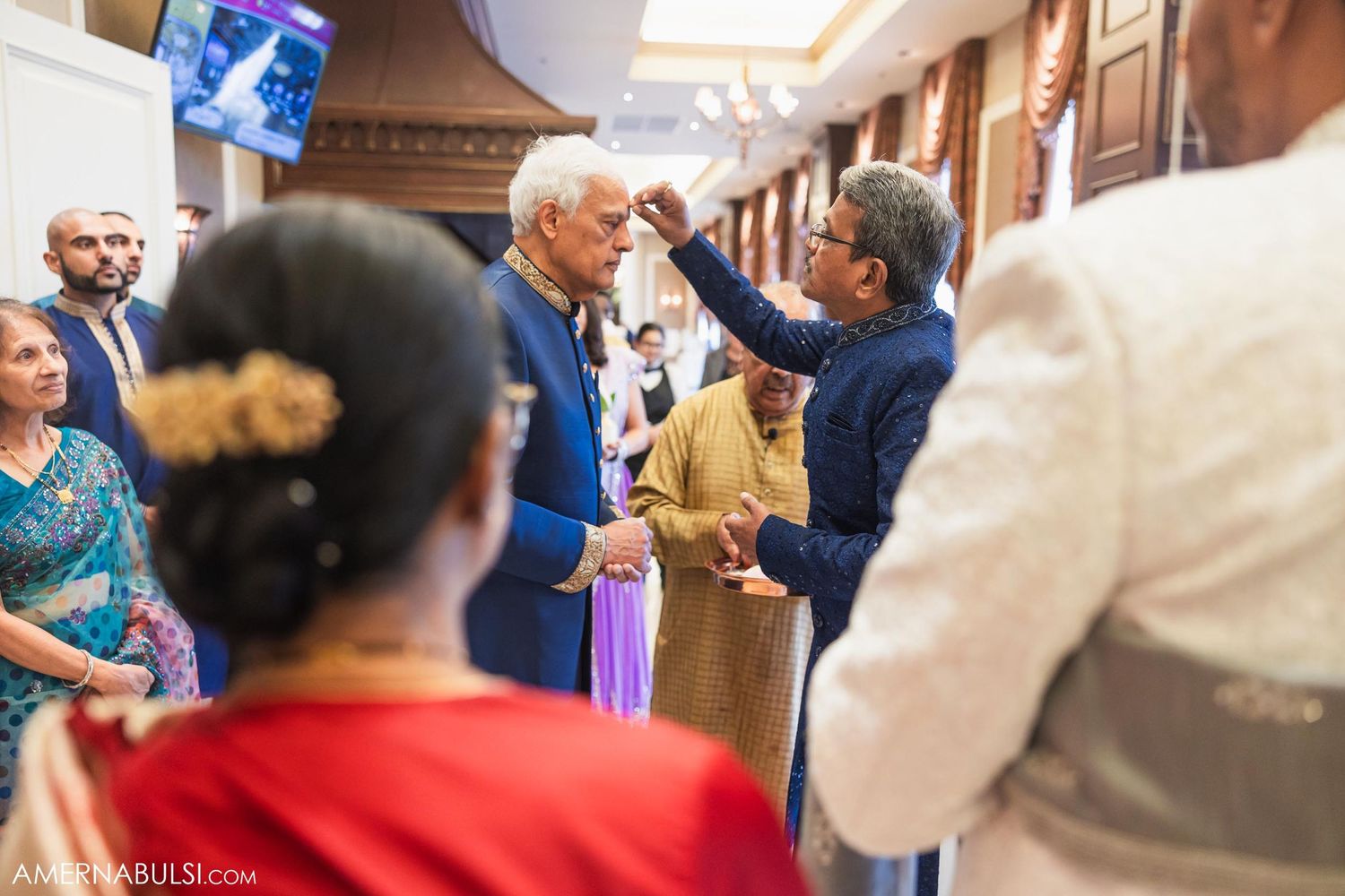 Celebratory moment during traditional wedding ceremony with guests watching.