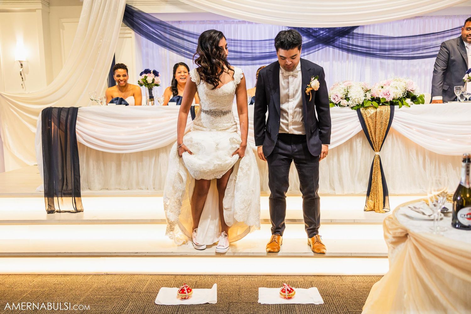 Couple performs synchronized dance steps on an elevated platform at their wedding reception.