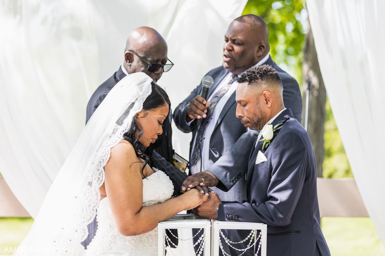 Intimate moment during wedding ceremony as couple exchanges vows at decorated altar.