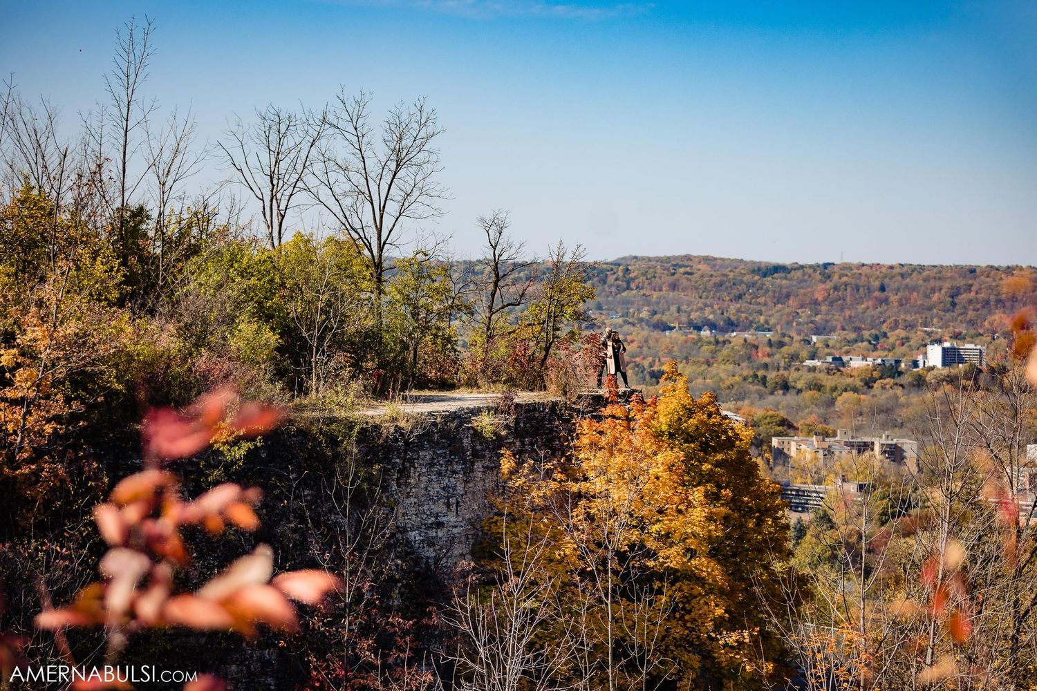 Autumn landscape with stone ruins overlooking a valley on a clear blue day.