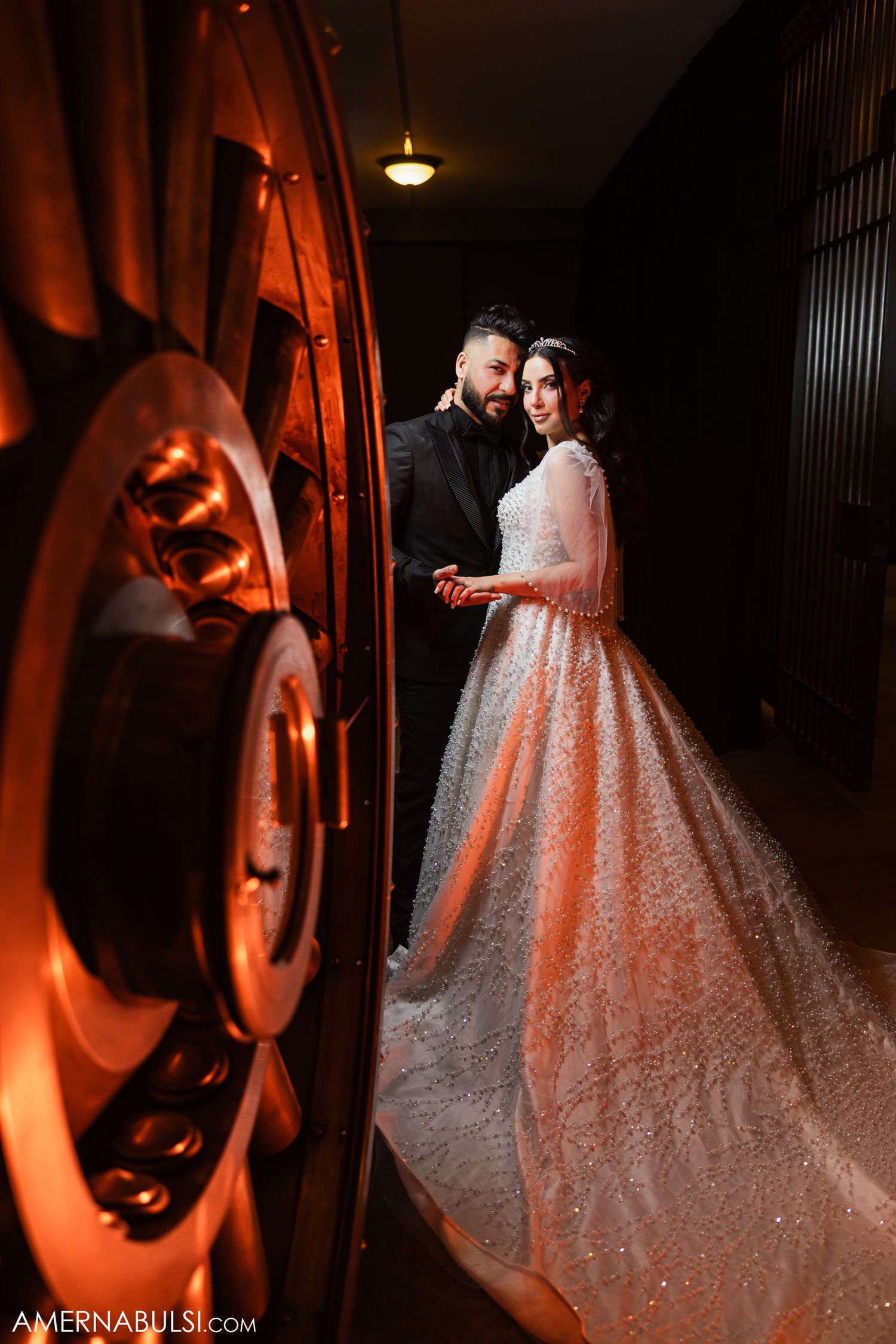 Romantic wedding photos with dramatic lighting show couple dancing and embracing in an elegant venue.