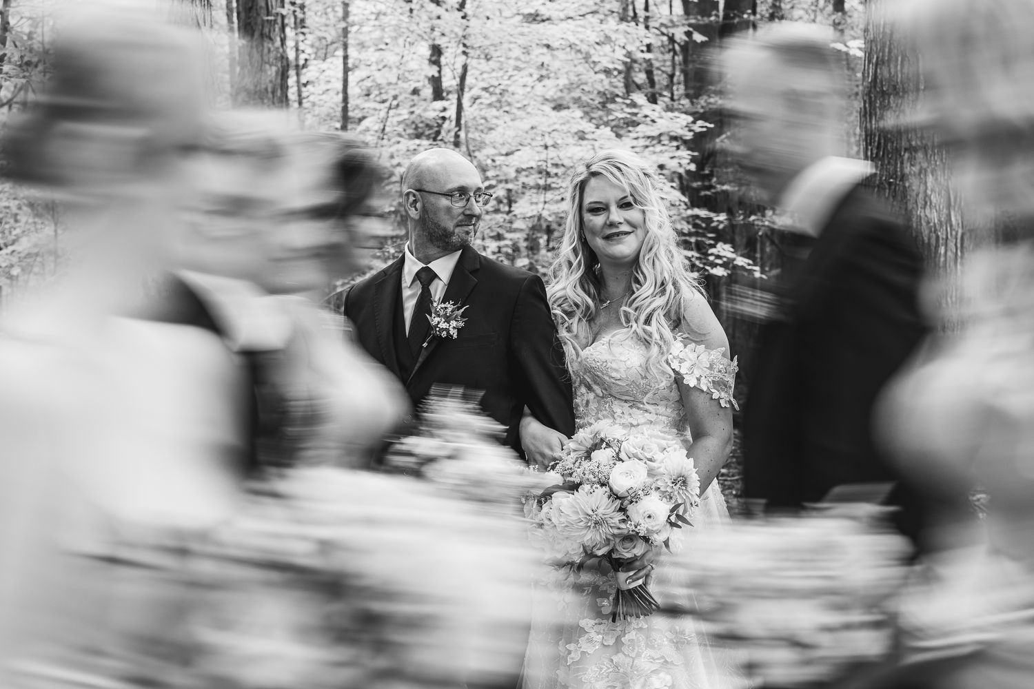 Black and white motion-blurred wedding ceremony photo showing movement and energy of the celebration.