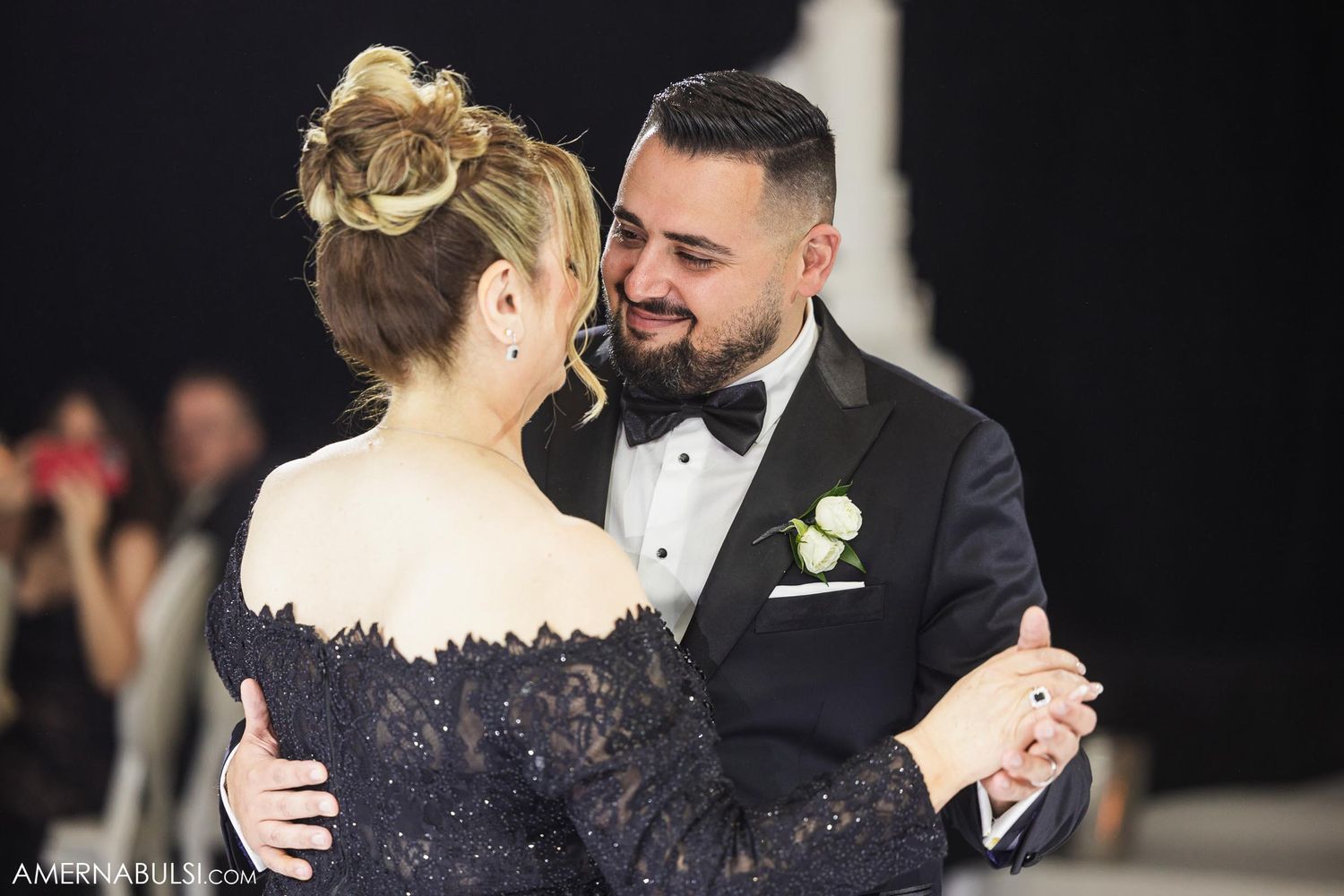 A couple shares an intimate dance together at their wedding reception in formal attire.